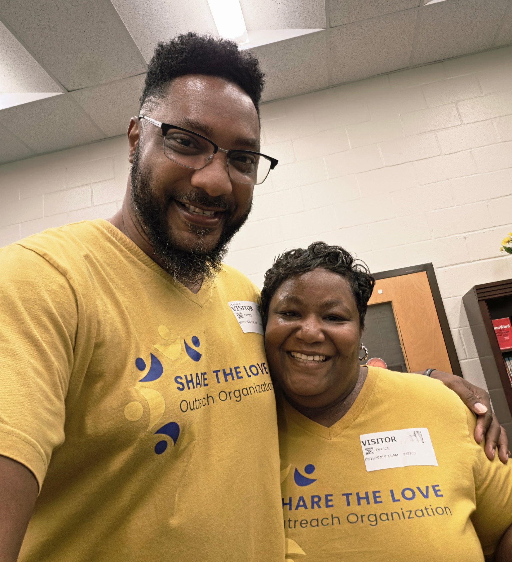 Two volunteers smiling together at the Sanders Elementary perfect attendance event