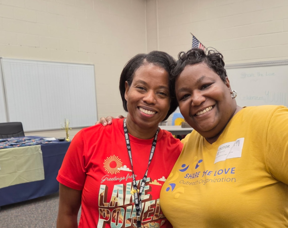 Share the Love volunteer and Sanders Elementary staff member smiling together at the perfect attendance pizza party