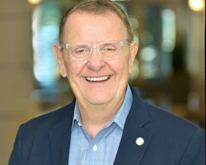 Jim Alexander smiling in a navy blazer